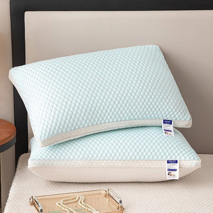 Two light blue pillows with quilted texture on a bed.